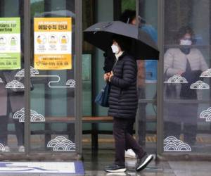 Una mujer con mascarilla pasa junto a carteles sobre precauciones contra el nuevo coronavirus en una estación de autobús en Seúl, Corea del Sur, el martes 25 de febrero de 2020. Foto: AP.