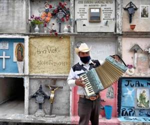 Un hombre toca el acordeón en un sepelio de víctimas d coronavirus. Foto: AP