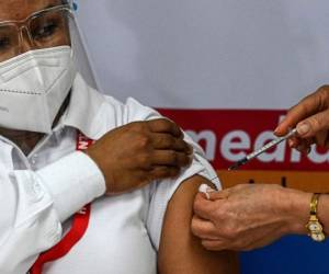 La enfermera Violeta Gaona es la primera persona en Panamá en ser inoculada con la vacuna Pfizer / BioNTech contra el covid-19, en el Hospital Santo Tomas de la Ciudad de Panamá, el 20 de enero de 2021. Foto: AFP