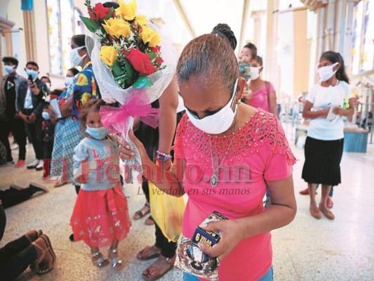 Doña Alicia estuvo postrada de frente a la Virgen de Suyapa durante su visita. La feligrés le dejó un ramo de rosas a La Morenita.