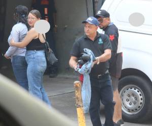 Don Samuel Juárez carga la ropa que su hijo José Manuel llevaba puesta ayer, mientras sus parientes retiran el cadáver de su vástago, en la morgue.