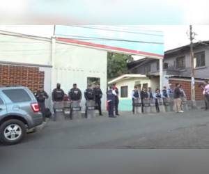 Varios agentes policiales resguardan la enttada principal de la SIT.