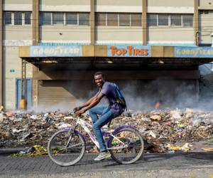 Un hombre monta una bicicleta en una carretera que quedó vacía por una huelga general en Port-au-Prince, Haití, el 28 de septiembre de 2022.
