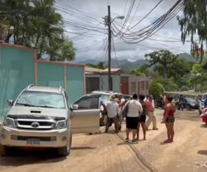 Vecino y familiares sacaron el cadáver del auto y lo trasladaron hacia una funeraria.