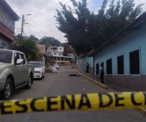 Agentes policiales resguardan la escena donde fue asesinado un joven frente a un kínder en la colonia Nueva Suyapa, Tegucigalpa.