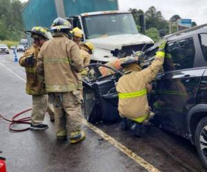 Miembros del Cuerpo de Bomberos intentaban rescatar el cadáver del conductor de la camioneta.