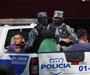 Dos personas son capturadas y llevadas en una patrulla de la Policía Nacional de El Salvador.