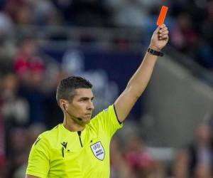 Árbitro mostrando la tarjeta roja en un partido profesional.