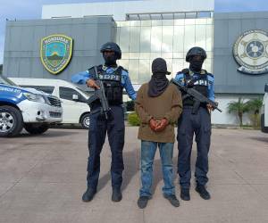 Dos agentes de la Dirección Policial de Investigaciones (DPI) custodian al menor de 17 años de edad, que habría ultimado a las dos personas.