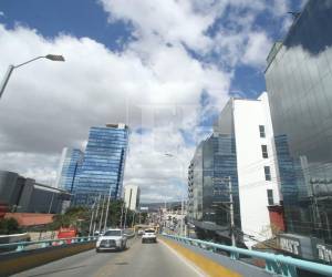 Vista de edificios en el paisaje urbano de Tegucigalpa captados desde el paso a desnivel que inicia en Casa Presidencial, donde el tránsito y las estructuras de concreto forman parte del escenario cotidiano.