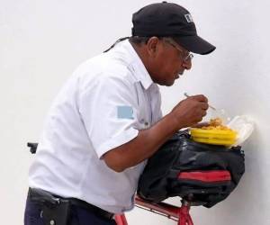 Hace unos días se hizo viral las imagenes de un guardia de seguridad comiendo sobre una mochila colocada en la montura de su bicicleta.