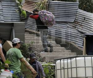 Los miembros de las familias desplazadas sacaron sus enseres envueltos en sábanas y cortinas.