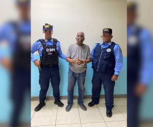 Agentes de la Dirección Policial de Investigaciones muestran al detenido, un hombre de 74 años.