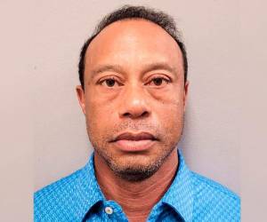 Tiger Woods es arrestado por agentes policiales tras verse involucrado en un accidente de tráfico.