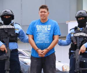 El detenido Cristian Rafael Martínez Fúnez, cuando era llevado a los tribunales, por los agentes de la DPI.