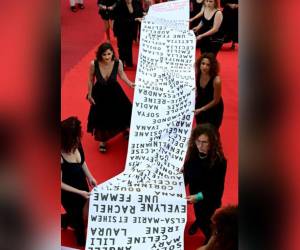 Miembros del movimiento feminista “Les Colleuses” sostienen una pancarta con los nombres de 129 mujeres que murieron como consecuencia de la violencia doméstica desde el último Festival de Cine de Cannes, en la alfombra roja antes de la proyección de la película “Holy Spider” durante la 75. edición del Festival de Cine de Cannes en Cannes.