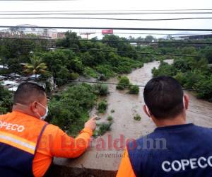 Dos empleados de Copeco vigilan el caudal de un río en Tegucigalpa, capital de Honduras.