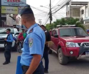 Agentes policiales resguardan el área del crimen, a la espera de médicos forenses.