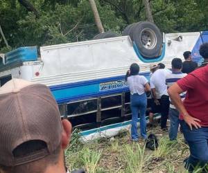 El autobús quedó volcado a un lado de la carretera, con las llantas hacia arriba. Los pasajeros salieron por la ventanas.