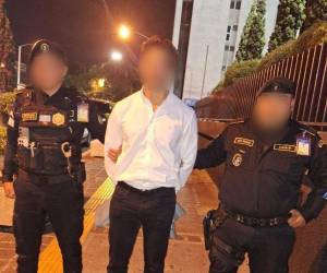 Agentes de seguridad custodian al hondureño detenido en el Aeropuerto Internacional La Aurora, en Guatemala, tras orden de captura con fines de extradición.