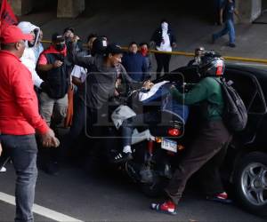 Con cascos, puñetazos y a patadas, un grupo demilitantes del partido Libertad y Refundación (Libre) atacaron a un motociclista y a su acompañante tras intentar pasar, cuando estos cerraron el paso como protesta a inmediaciones del Infop. Aquí las fotos.