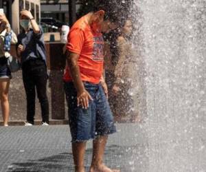 Los niños juegan en la escultura a base de agua del artista Jeppe Hein titulada “Changing Spaces” en el Rockefeller Center Plaza, en la ciudad de Nueva York.