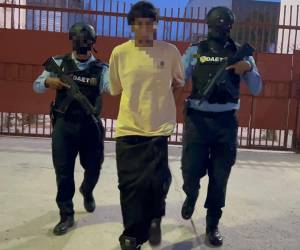 El detenido Carlos Antonio Ponce Pérez, es custodiado por dos agentes policiales asignados a la División Anti Extorsión y Asociaciones Terroristas (DAET).