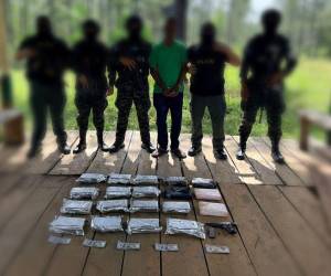 El detenido es custodiado por efectivos militares, junto a la evidencia de los 19 kilos de cocaína, el dinero y el arma de fuego.