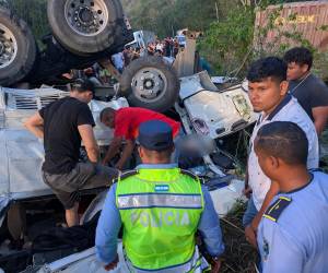 Equipos de rescate y voluntarios trabajan intensamente entre el amasijo de hierros para liberar a las víctimas del accidente en la aldea El Camalote, desvío a La Ceibita, Quimistán. Hay preliminarmente ocho víctimas fatales.