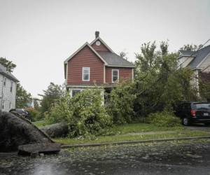 Un árbol se apoya contra las líneas eléctricas y una casa después de que la tormenta postropical Fiona azotara en Sydney, Nueva Escocia, en la isla Cape Breton en Canadá.