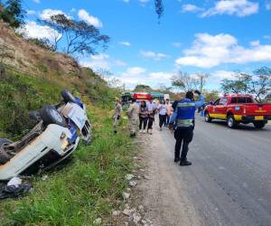 La patrulla en la que se transportaban los agentes policiales se salió de la carretera debido al fuerte impacto y quedó con las llantas hacia arriba.