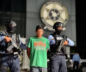 José Adonay Martínez Martínez es custodiado por dos agentes policiales la ser ingresado a la Dirección Policial de Investigaciones (DPI).