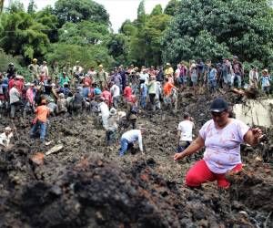 Los lugareños y los equipos de rescate se ven en el lugar de un deslizamiento de tierra en el municipio de Andes, departamento de Antioquia, Colombia, el 14 de julio de 2022.