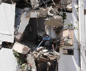 Al menos 20 edificios sufrieron graves daños por consecuencia del terremoto. Personas salen de los escombros de un edificio colapsado en el departamento del Valle del Cauca.