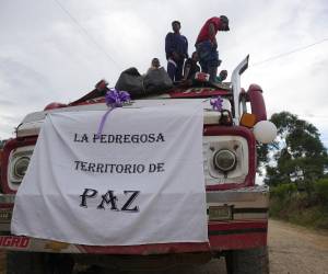 La comunidad, acongojada por la tragedia, atravesó caminos de tierra entre casas dispersas, mientras agitaban banderas y globos blancos en señal de respeto a la violencia.