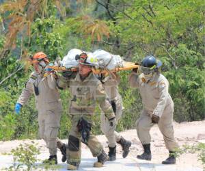 Miembros del Cuerpo de Bomberos de Honduras descendieron hasta un pequeño abismo de aproximadamente 75 metros para rescatar los tres cuerpos carbonizados que fueron hallados la mañana de este martes 12 de mayo, en una zona boscosa del cerro de la aldea El Cimarrón, en Francisco Morazán.