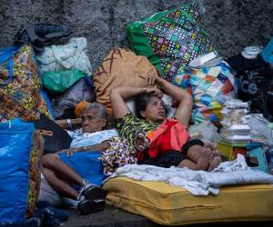 Personas esperan afuera de un edificio afectado por el terremoto, este sábado en Caracas. Las duras imágenes muestran la realidad que atraviesa Venezuela, donde familias deben dormir en la calle porque sus hogares se derrumbaron o por temor a nuevas réplicas.