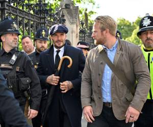 David Beckham, de 47 años, fue descubierto por la prensa mientras esperaba en la fila, vestido con traje, corbata y abrigo negros. Llevaba también una gorra y un paraguas del mismo color.