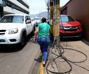 Vecinos y comerciantes alertan sobre cables caídos en la avenida Juan Ramón Molina, detrás del Congreso Nacional, los cuales permanecen desde hace tres semanas sin atención.