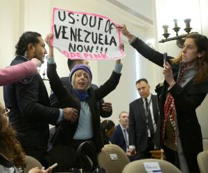 La integrante de la organización feminista de izquierda CodePink, Medea Benjamin, sostiene un cartel durante una sesión extraordinaria del Consejo Permanente de la Organización de Estados Americanos este martes, en Washington (Estados Unidos).