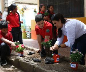 Lynda Marín, gerente de Asuntos Corporativos de Nestlé, entrega plantas a los estudiantes y les enseña a reciclar maceteras como parte del programa Reciclando ando con Nestlé.