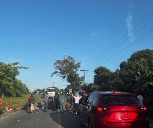 Un grupo de campesinos y pobladores mantienen bloqueada la carretera CA-13, entre El Progreso y Tela, como parte de una jornada de protestas que afectan este lunes la circulación en varios ejes carreteros del país. Una de las exigencias es la derogación del decreto de Ley para el Fortalecimiento y Protección del Sector Agroindustrial, Proyectos de Energía, Turismo, Ganadería y Pequeños Productores Agrícolas.