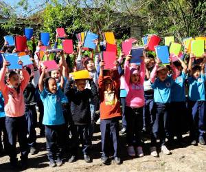 Niños y niñas sostienen sus nuevos cuadernos, símbolo de esperanza y compromiso con su educación durante la vigésima tercera edición de la campaña Maratón del Saber.