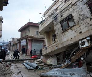 Los residentes caminan a lo largo de un edificio derrumbado luego de un terremoto en la ciudad de Jandaris, en el campo de la ciudad de Afrin, en el noroeste de Siria, en la parte de la provincia de Alepo controlada por los rebeldes, el 6 de febrero de 2023.