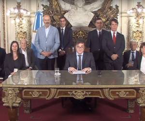Esta captura de pantalla obtenida de un video transmitido por la Presidencia de Argentina muestra al presidente Javier Milei (C) entregando un mensaje a la nación desde el palacio presidencial de la Casa Rosada en Buenos Aires el 20 de diciembre de 2023.