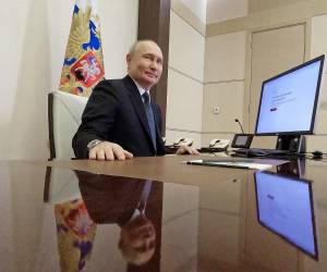 En esta fotografía de grupo distribuida por la agencia estatal rusa Sputnik, el presidente ruso Vladimir Putin vota en línea en las elecciones presidenciales en la residencia estatal Novo-Ogaryovo, en las afueras de Moscú.