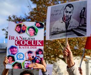 Las personas sostienen pancartas con retratos del rapero iraní Toomaj Salehi, arrestado en Irán.
