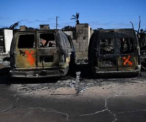 Los marcadores de pintura en aerosol de un equipo de búsqueda y rescate indican el estado de búsqueda de vehículos después de un incendio forestal en Lahaina, en el oeste de Maui.