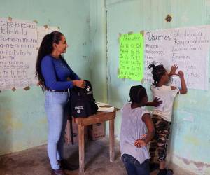Con un pizarrón a base de papel les enseña el abecedario y sus quehaceres académicas a los niños que buscan el pan del saber en la escuela inaugurada por la hondureña Mayuri Ramírez.