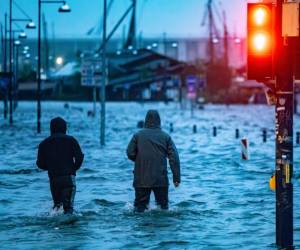 Personas caminan por una de las ciudades inundadas en al norte de Alemania.